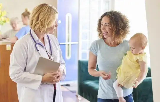 A young couple is grocery shopping, holding jars of pasta sauce.