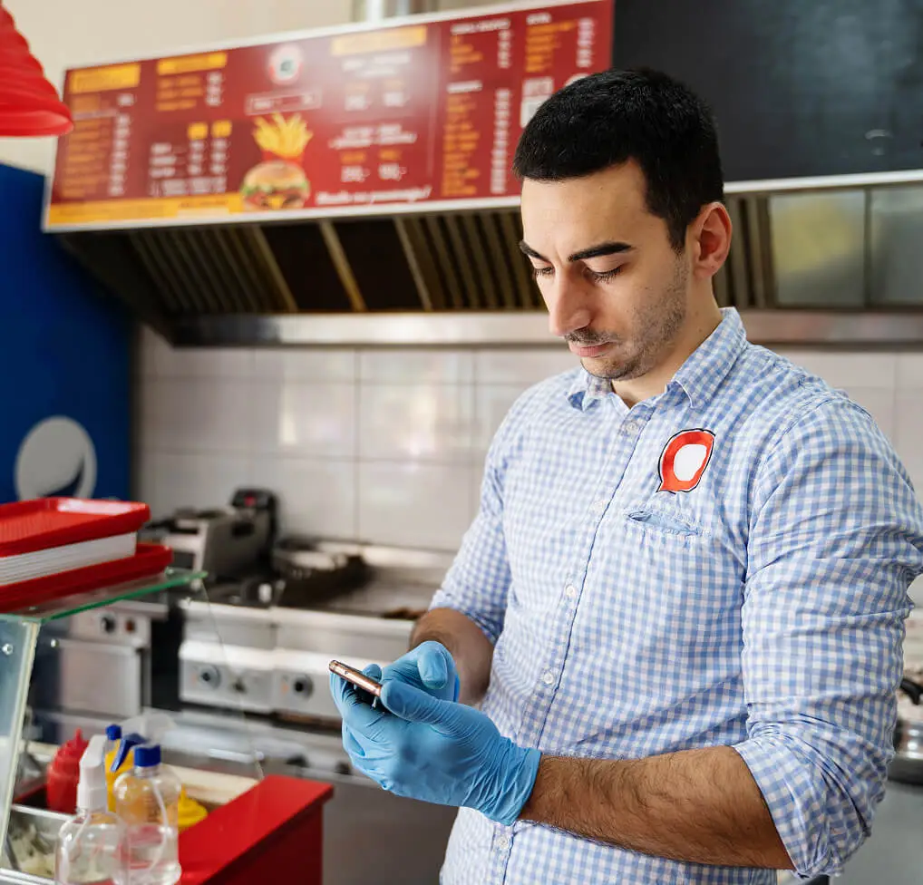 Man selecting fast food restaurant music from his smartphone