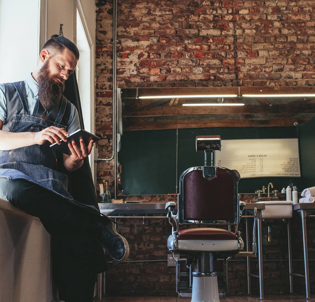 Man with touchscreen tablet selecting salon background music