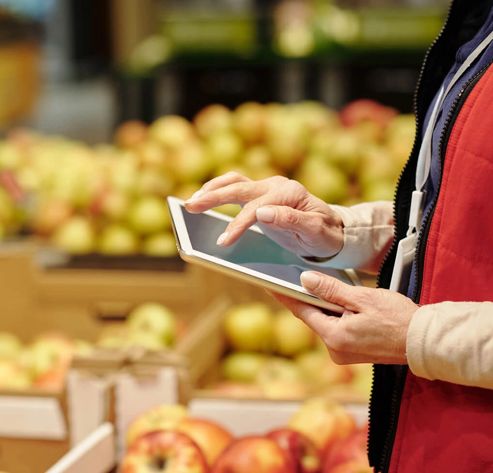 Woman selecting ambient supermarket background music on a touchscreen tablet
