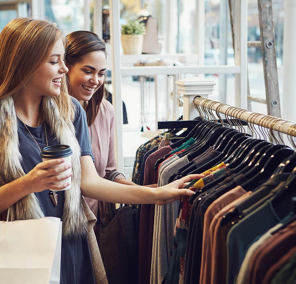 Two women shopping for clothes, enjoying SiriusXM business music.