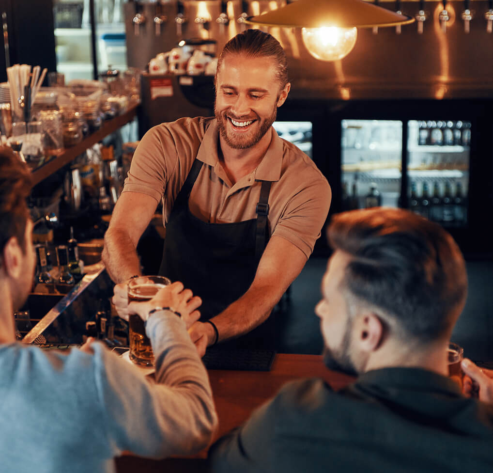Bartender serving drinks to customers with SiriusXM music playing.